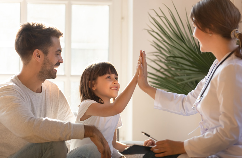 Healthcare provider giving high‑five to child