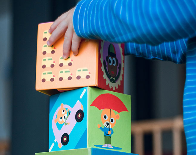 Child stacking colorful toy blocks