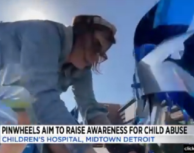 Volunteer placing blue pinwheels display